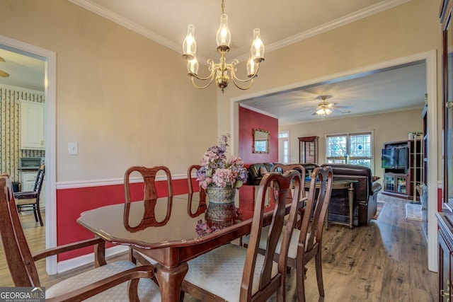 dining space featuring hardwood / wood-style floors, ceiling fan with notable chandelier, and ornamental molding