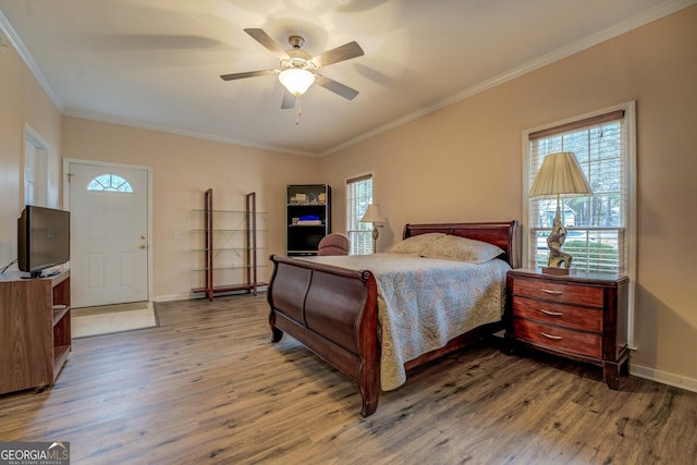 bedroom with hardwood / wood-style flooring, ceiling fan, and ornamental molding