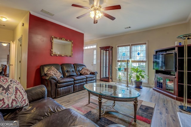 living room featuring light hardwood / wood-style flooring, ornamental molding, and ceiling fan