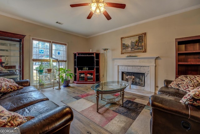 living room with hardwood / wood-style flooring, a fireplace, and ornamental molding