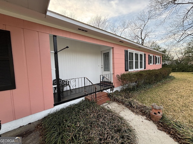 view of exterior entry with a yard