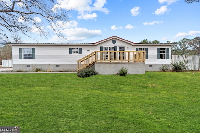 rear view of property with a wooden deck and a lawn