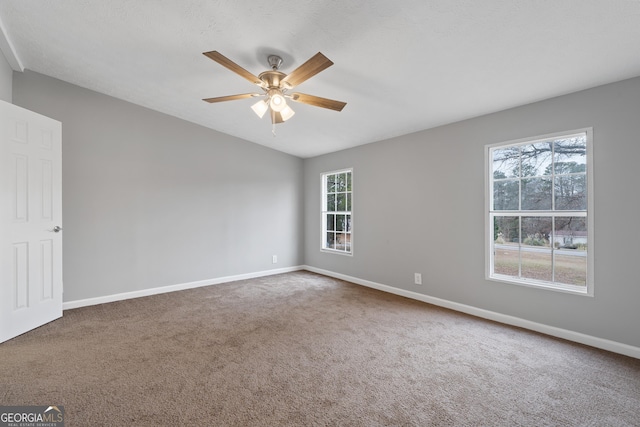 empty room featuring vaulted ceiling, carpet flooring, and ceiling fan