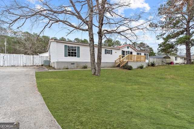 manufactured / mobile home featuring a front lawn and a deck