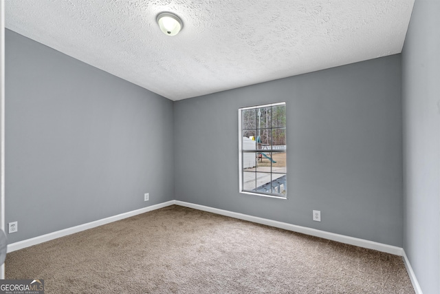 spare room with carpet flooring and a textured ceiling