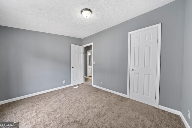 unfurnished bedroom with carpet floors and a textured ceiling