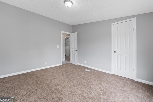 carpeted spare room with a textured ceiling