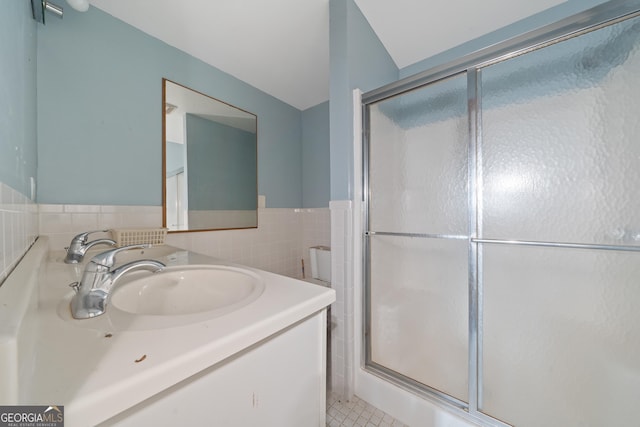 bathroom with vanity, tile walls, and an enclosed shower