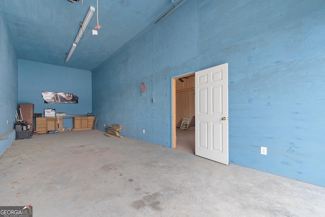 additional living space with a towering ceiling and concrete flooring