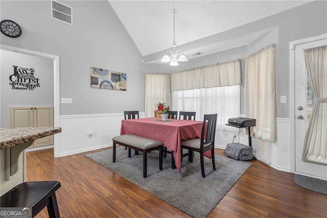 dining area with high vaulted ceiling, a chandelier, and dark hardwood / wood-style flooring