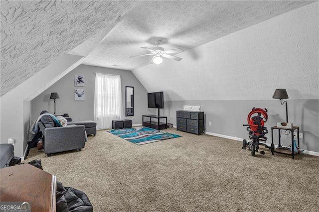 interior space featuring vaulted ceiling, ceiling fan, carpet floors, and a textured ceiling