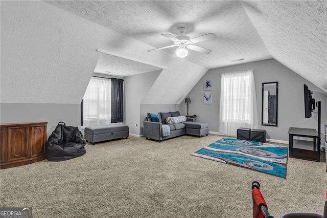 playroom featuring lofted ceiling, ceiling fan, carpet floors, and a textured ceiling