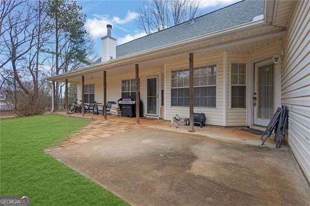 rear view of house with a patio and a lawn