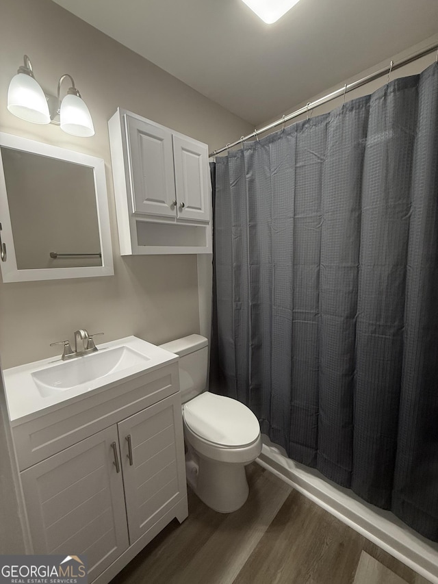 bathroom with vanity, hardwood / wood-style floors, curtained shower, and toilet