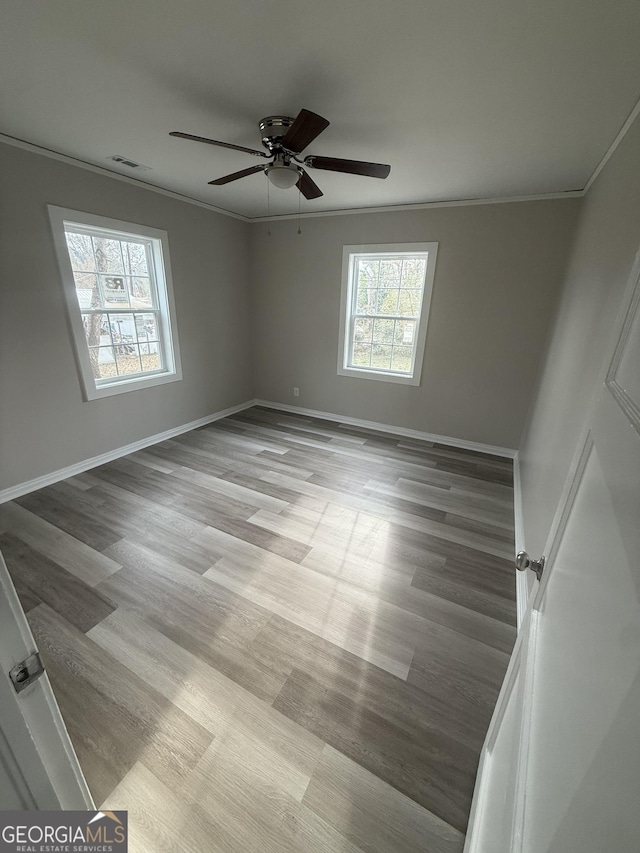 spare room with crown molding, ceiling fan, and light wood-type flooring