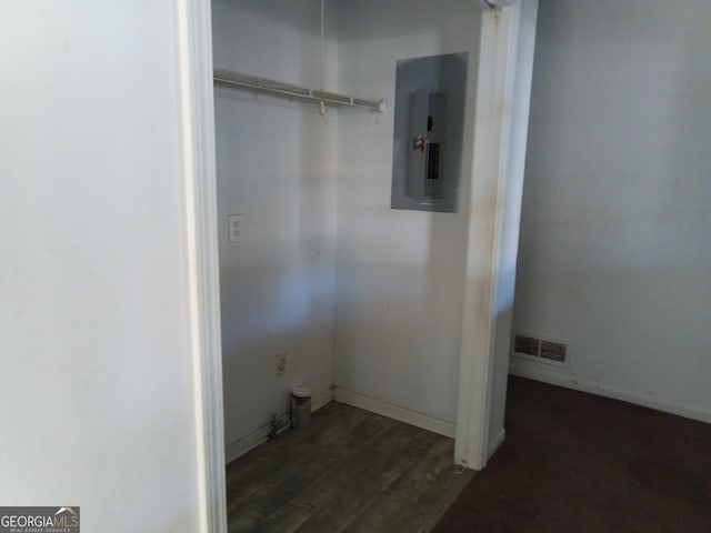 laundry room featuring dark wood-style flooring, electric panel, and visible vents