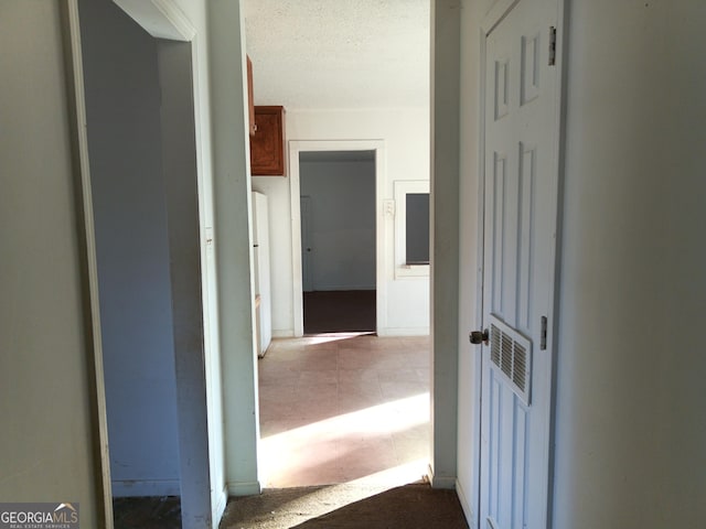 hallway with a textured ceiling and visible vents