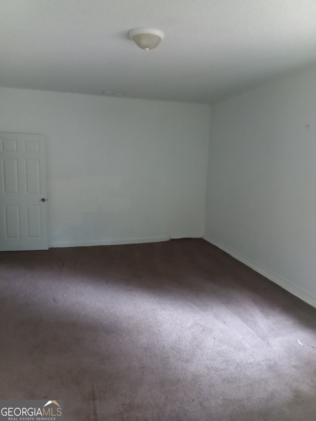 empty room with dark colored carpet