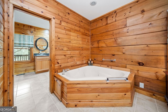 bathroom with a bath, tile patterned floors, wood walls, and vanity