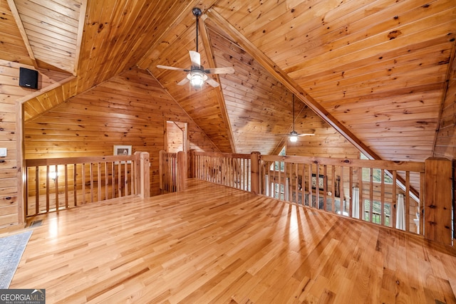 additional living space with light hardwood / wood-style floors, wood walls, and wooden ceiling