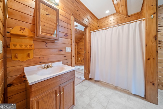 bathroom featuring wooden walls, a skylight, and vanity