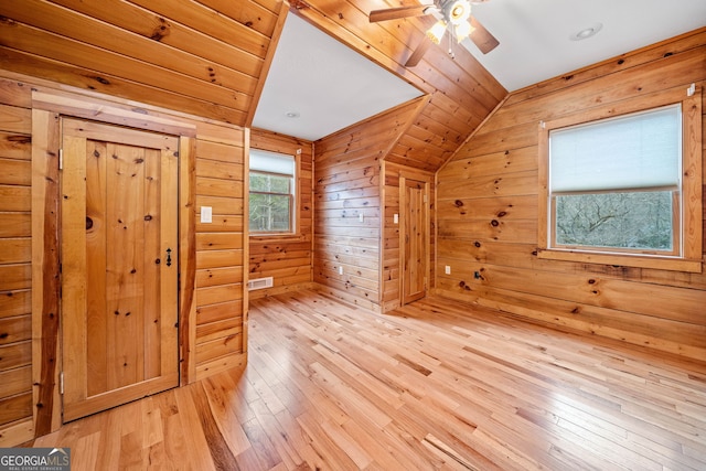 bonus room with lofted ceiling, light hardwood / wood-style floors, ceiling fan, wooden walls, and wood ceiling