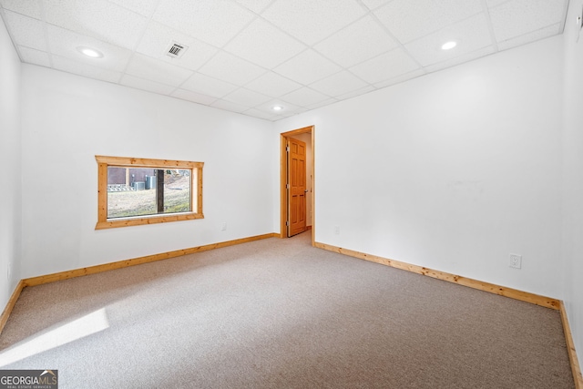 empty room with a paneled ceiling and carpet