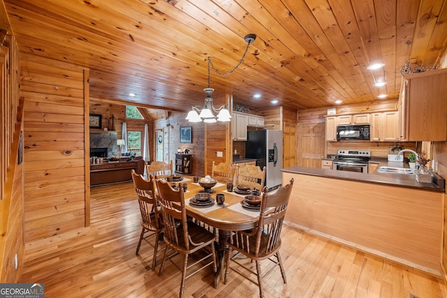 dining space featuring sink, light wood-type flooring, a fireplace, and wood ceiling