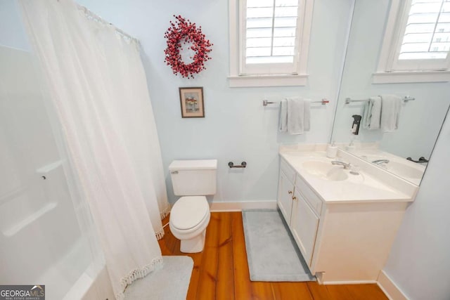 full bathroom with hardwood / wood-style floors, vanity, a wealth of natural light, and toilet