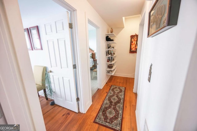 corridor with light hardwood / wood-style flooring