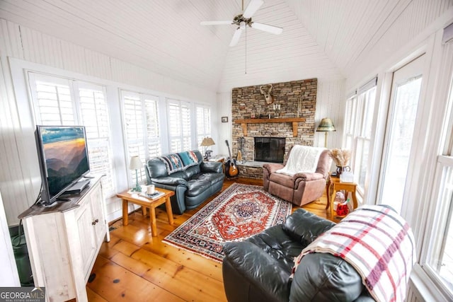 living room featuring wood-type flooring, lofted ceiling, a wealth of natural light, and a fireplace