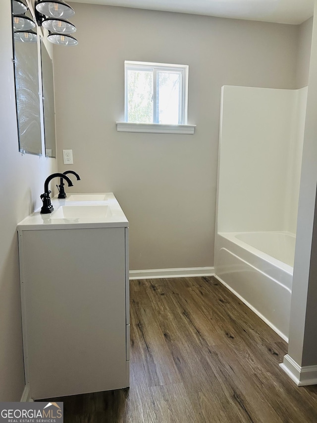 bathroom with shower / bath combination, wood-type flooring, and vanity