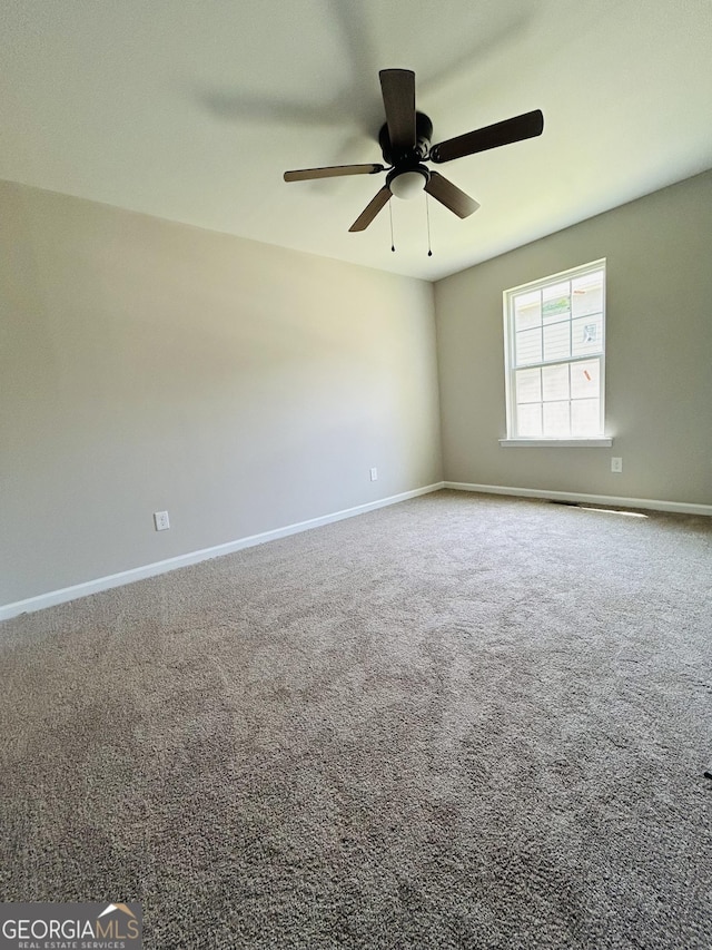 carpeted spare room featuring ceiling fan