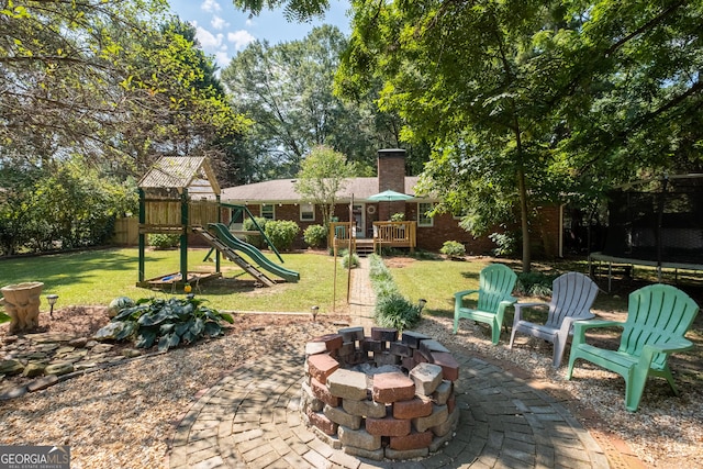 view of patio / terrace with a trampoline, a fire pit, and a playground