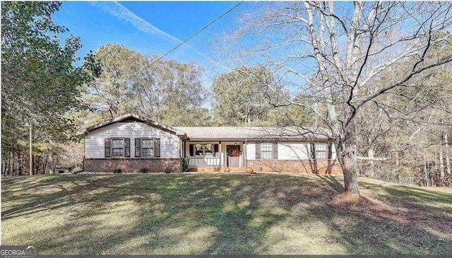 ranch-style home with covered porch and a front yard