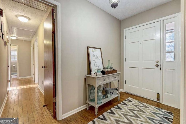 foyer featuring wood-type flooring and a textured ceiling