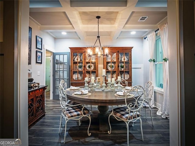 dining space featuring coffered ceiling, dark hardwood / wood-style flooring, a chandelier, and beam ceiling