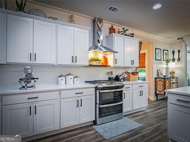 kitchen featuring white cabinetry, double oven range, backsplash, and wall chimney range hood