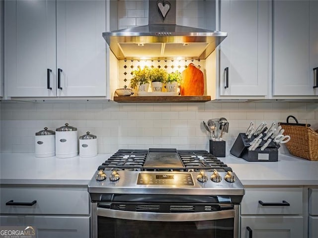 kitchen featuring tasteful backsplash, wall chimney exhaust hood, and gas stove