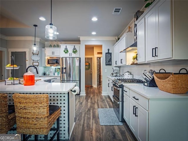 kitchen featuring white cabinetry, a kitchen breakfast bar, hanging light fixtures, a kitchen island with sink, and stainless steel appliances