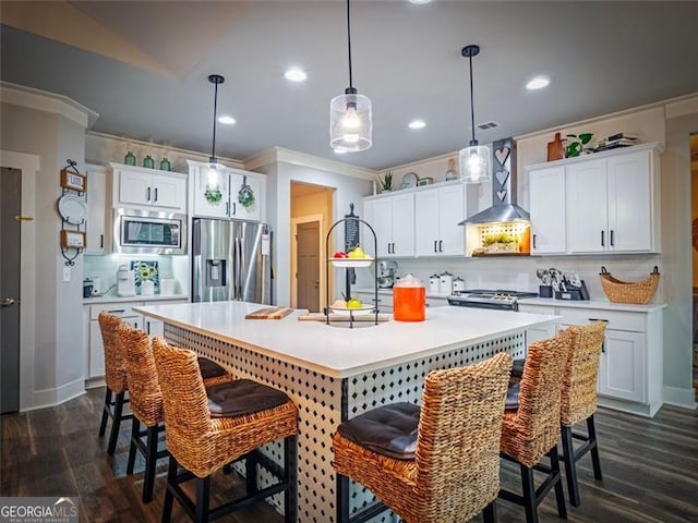 kitchen with stainless steel appliances, white cabinetry, a center island with sink, and wall chimney range hood