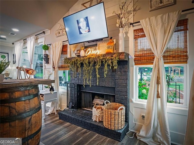 interior space featuring wooden walls, a fireplace, and hardwood / wood-style floors