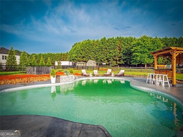 view of pool with a gazebo and an outdoor bar