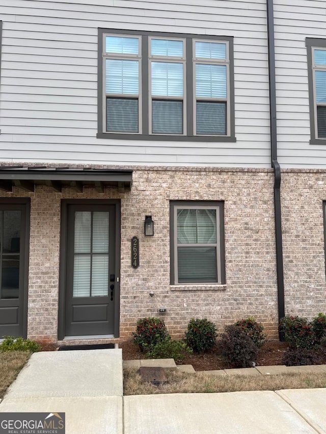 property entrance featuring brick siding