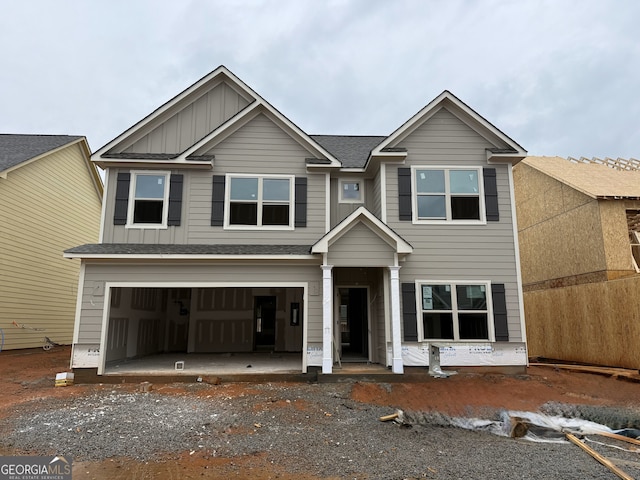 view of front of house featuring board and batten siding, an attached garage, and roof with shingles