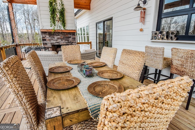 dining room featuring wood-type flooring, wooden walls, and an outdoor stone fireplace