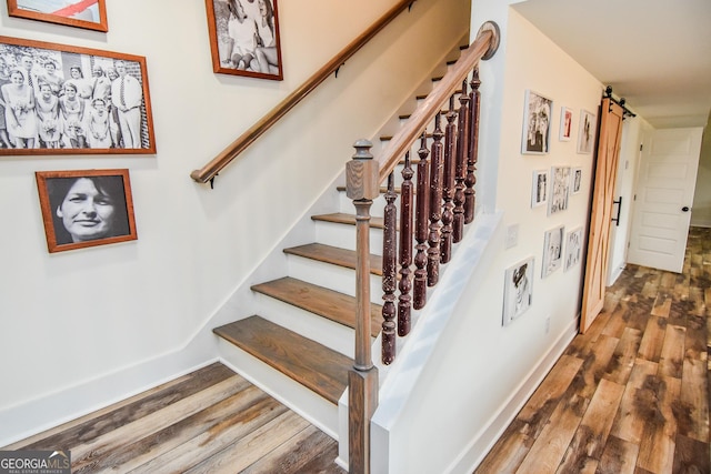 staircase featuring hardwood / wood-style floors and a barn door