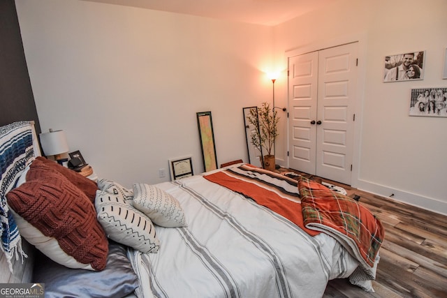 bedroom with wood-type flooring and a closet