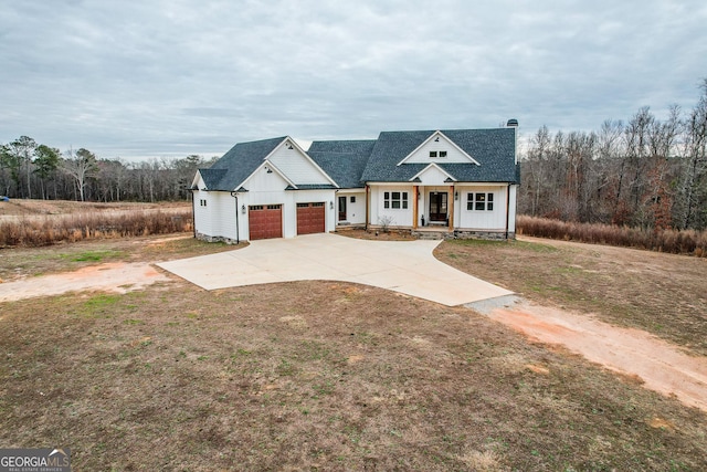 view of front facade with a garage, a front yard, and covered porch