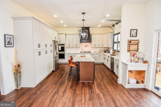 kitchen with a breakfast bar, sink, a center island, custom range hood, and stainless steel appliances